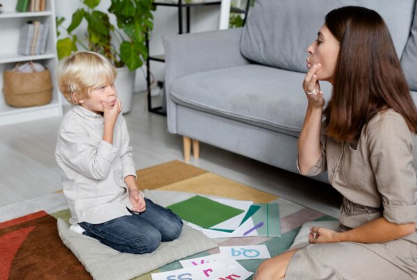 young woman doing speech therapy with little boy 1 1