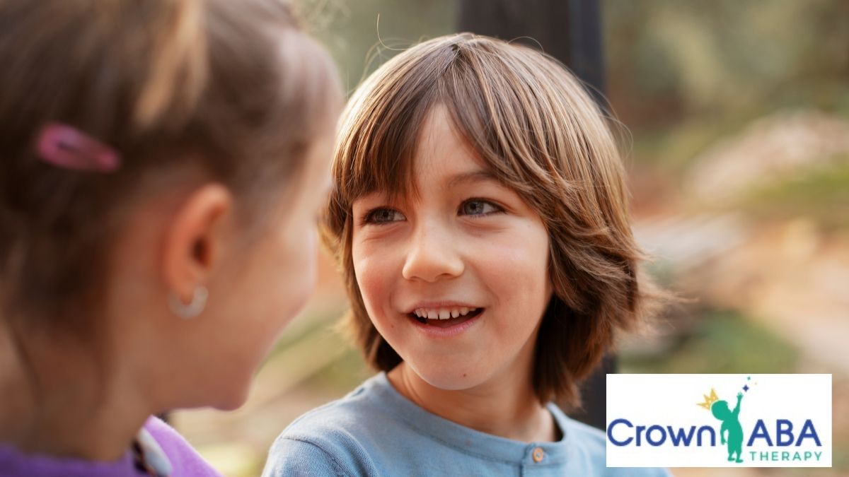 Outdoors, a young boy engages with a peer to practice ABA communication skills.
