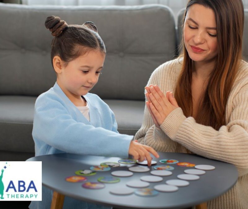 A therapist supports a young child during in-home play therapy to build social skills in the living room.