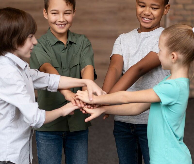 Kids join hands at center of circle practicing social skills through ABA activity.